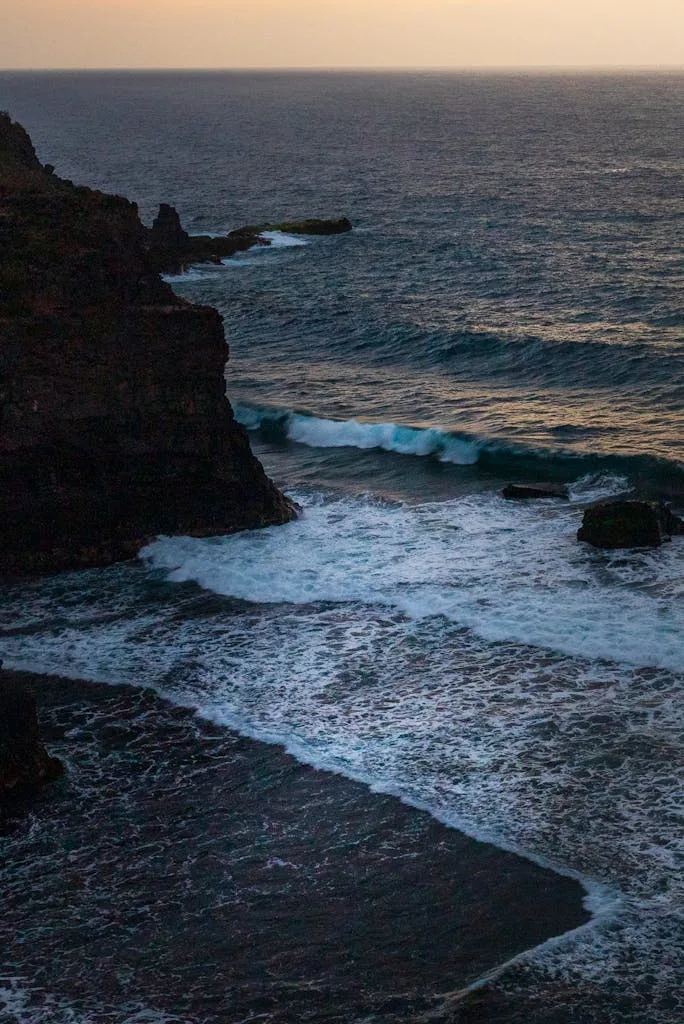 A breathtaking aerial view of natural rocky coastline and sea waves in Playa de las Americas, Spain.