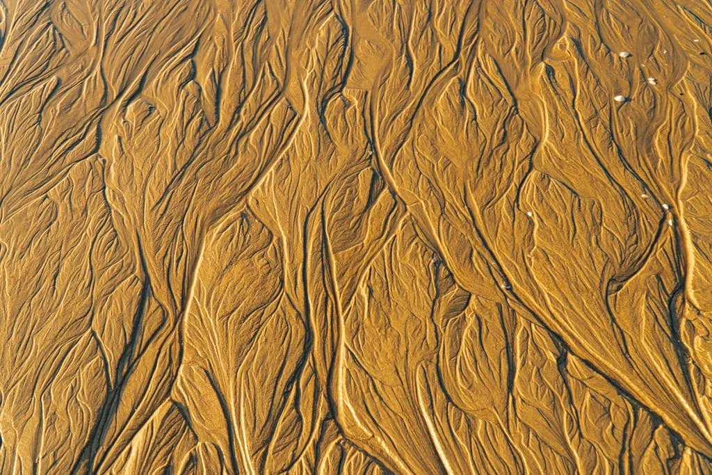 Abstract sand patterns form natural artistry on a beach in Vietnam.