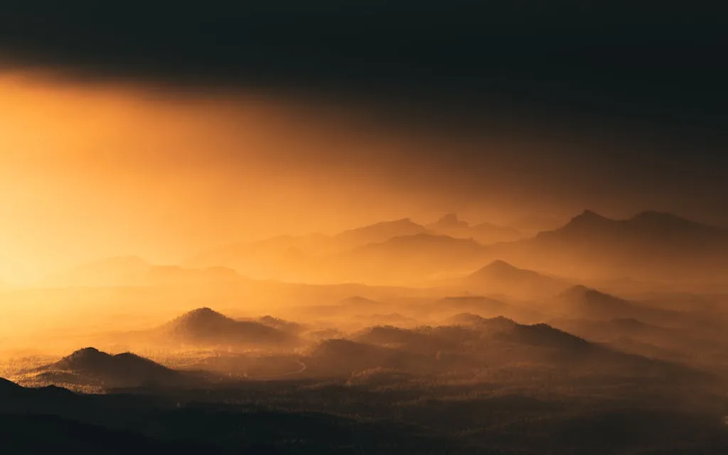 Silhouetted mountains under a dramatic, orange sunset in Tenerife, Spain.